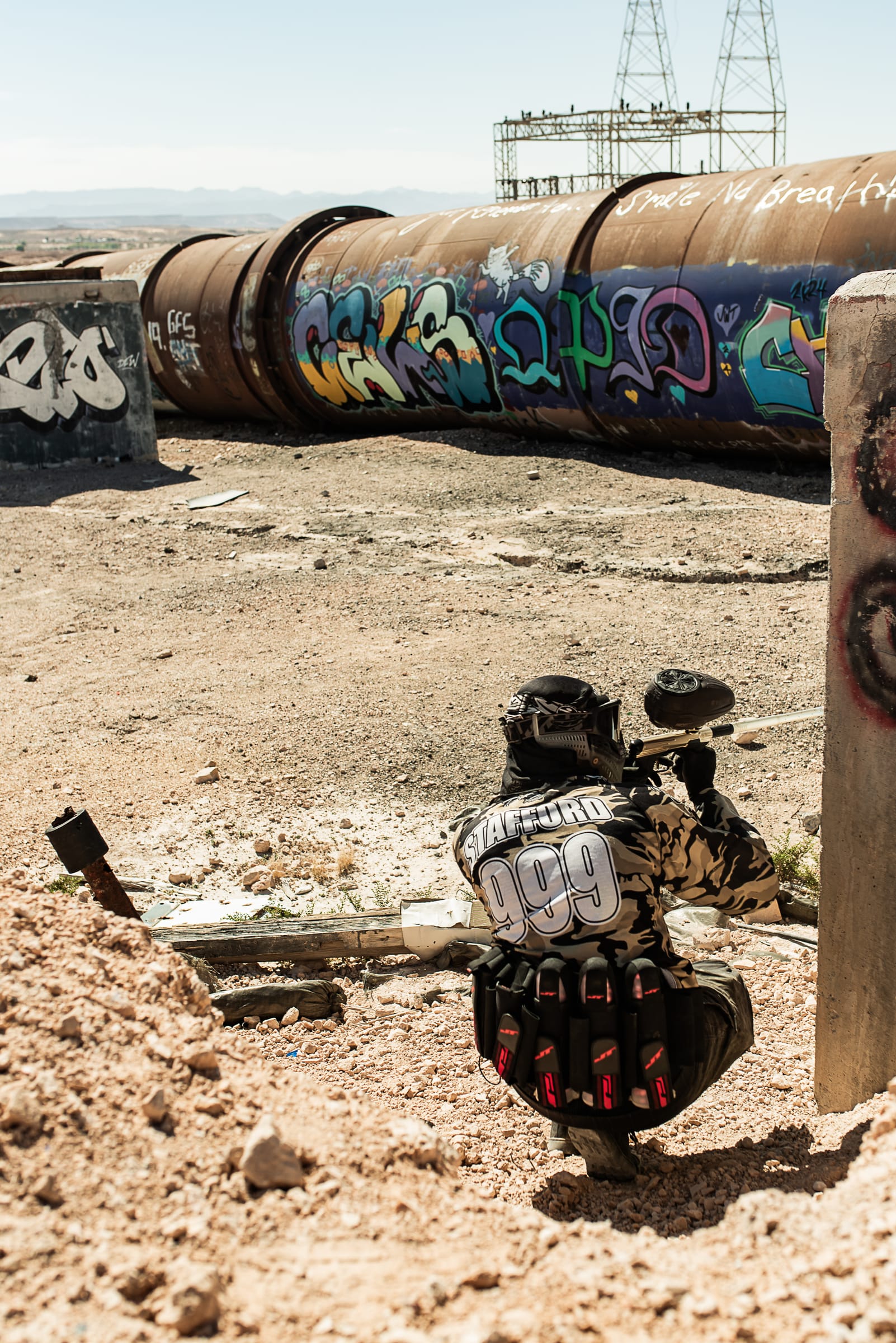 A player crouched behind cover along the graffiti pipeline