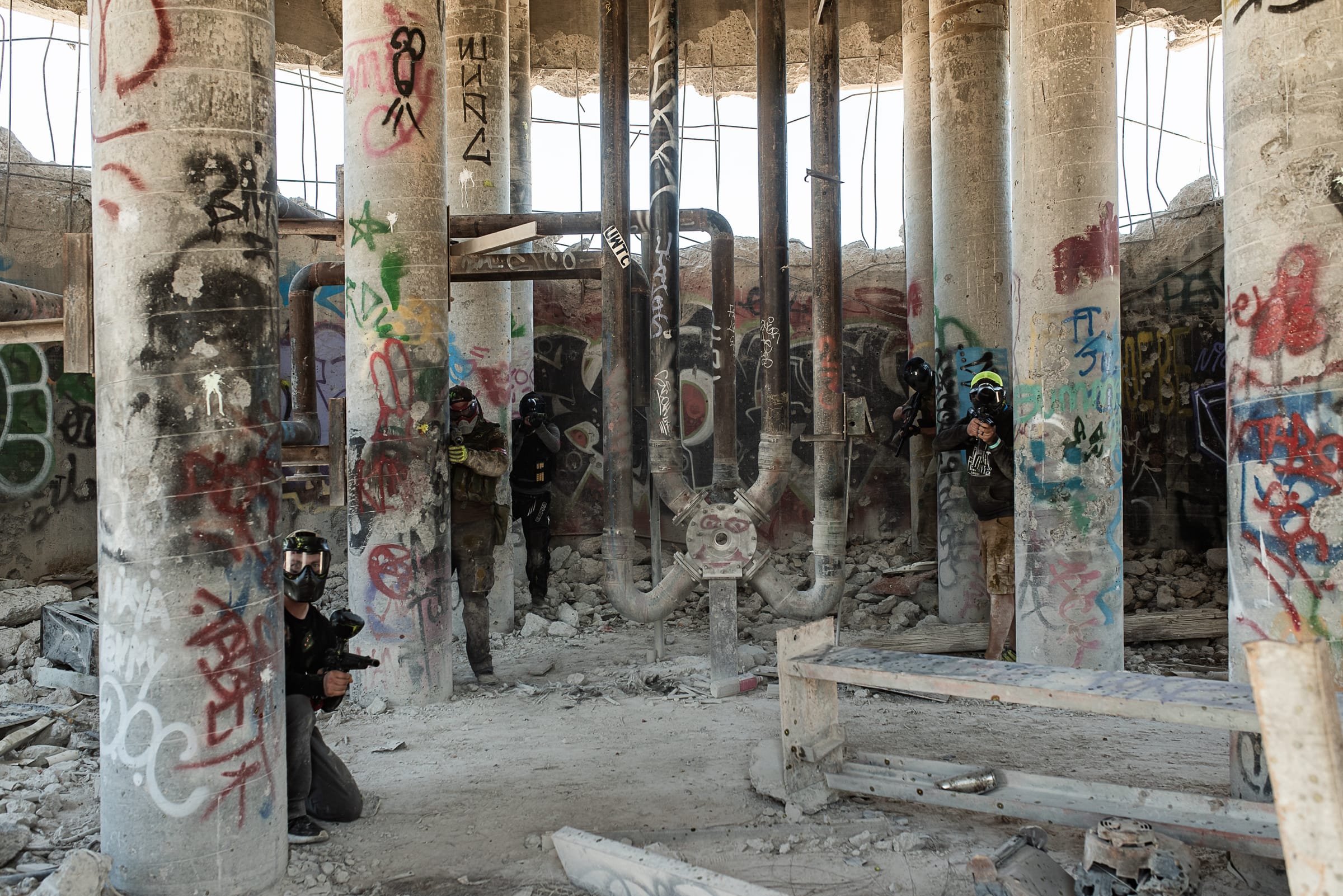 Players holding cover among the graffiti-covered pillars at Cement Shield.