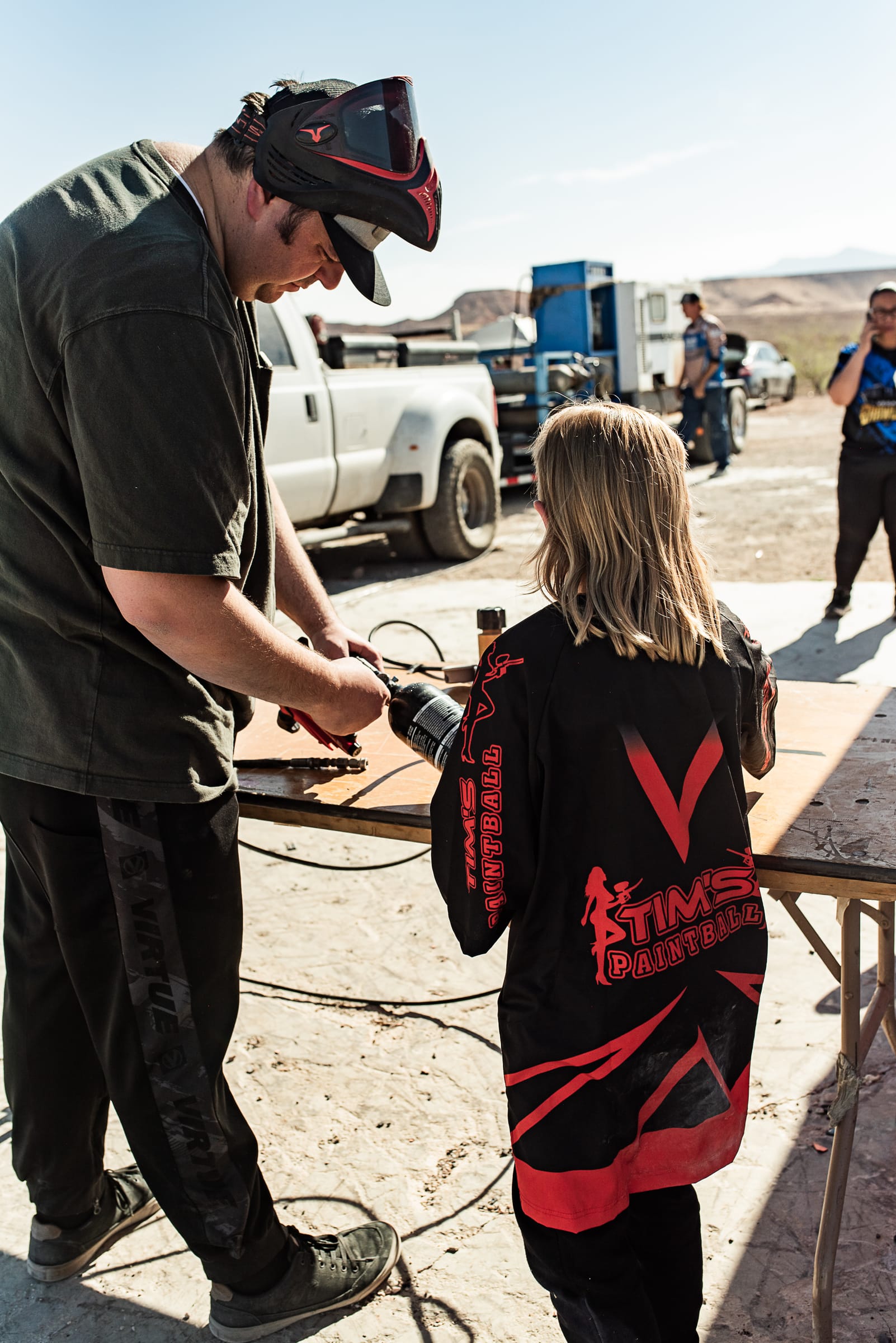 A Barrels Up tech fills a young player's tank at the staging table.